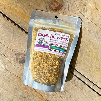 Packaged elderflowers on a wooden surface