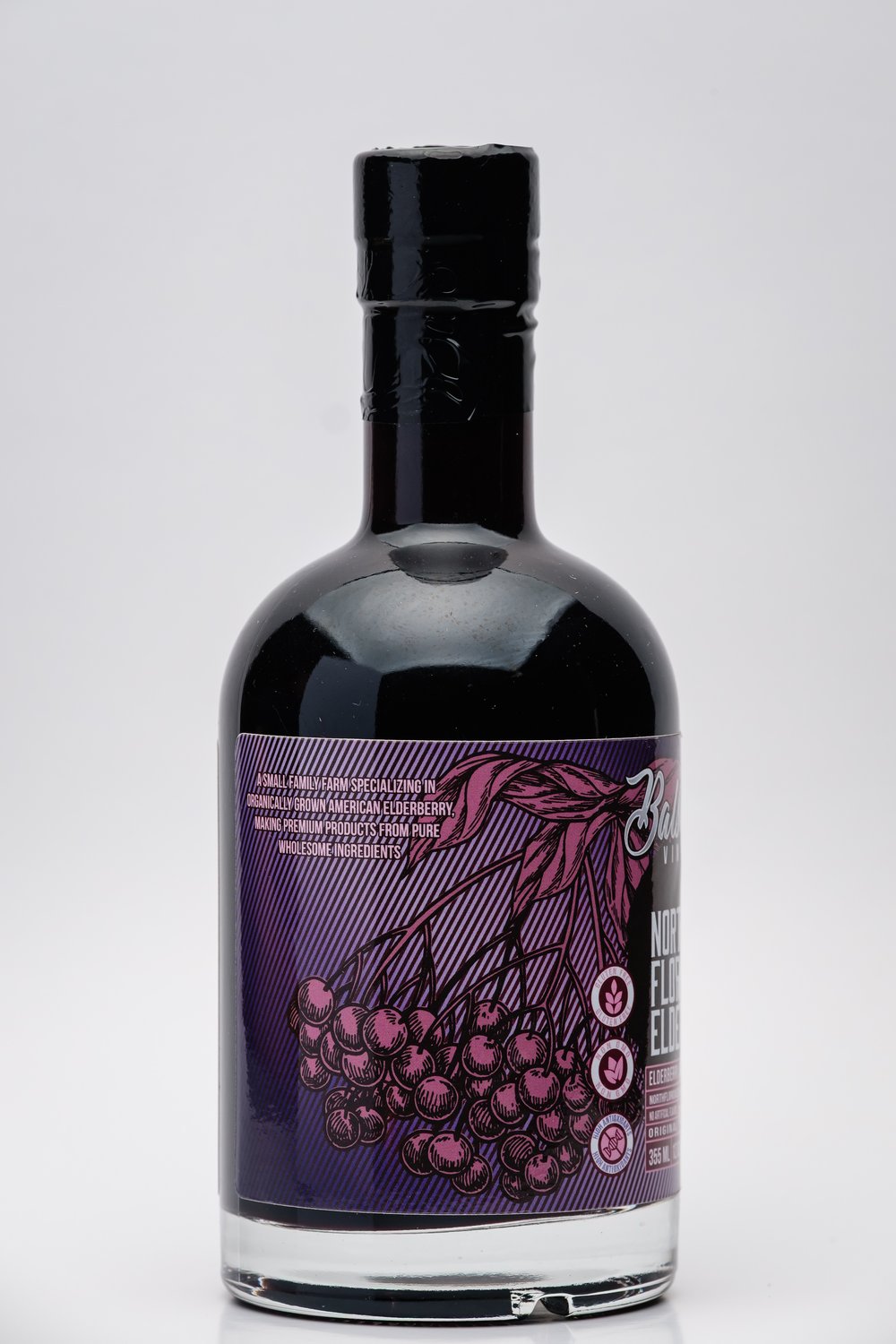 Bottle of North Florida Elderberry Balsamic Vinegar with a purple label featuring a design of berries on a white background