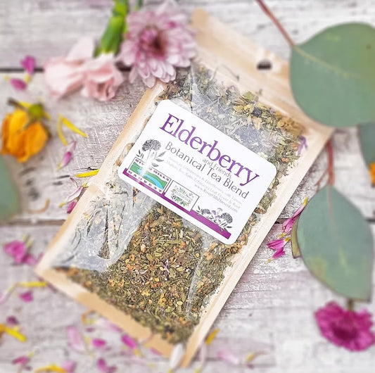 Packaged elderberry botanical tea blend with flowers and leaves on a wooden surface