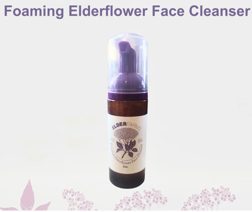 Foaming elderflower face cleanser bottle on a light purple background with floral designs.