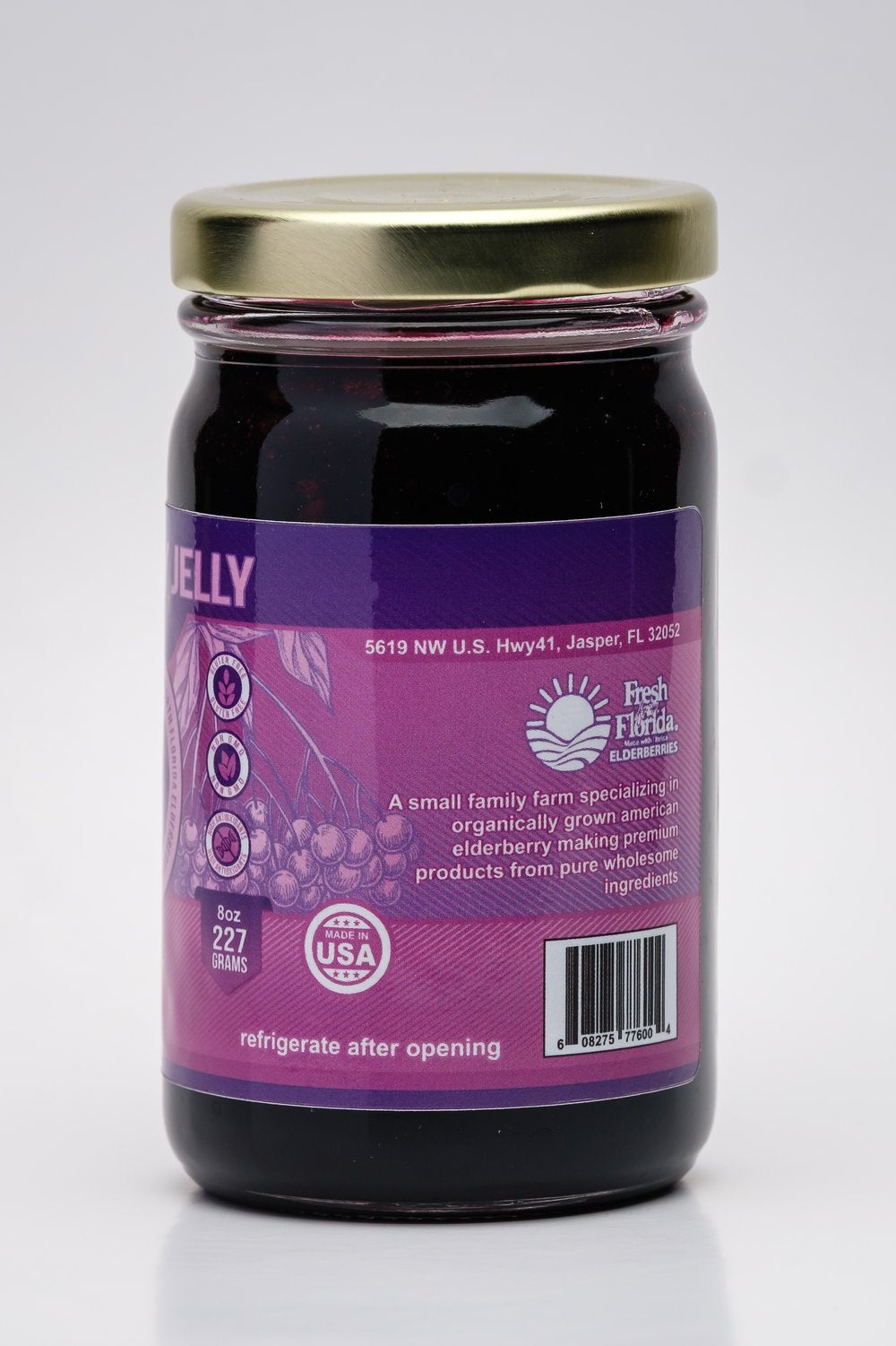 Jar of elderberry jelly with a purple label on a white background