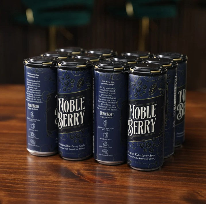 Multiple cans of NobleBerry soda arranged on a wooden surface with a blurred background.