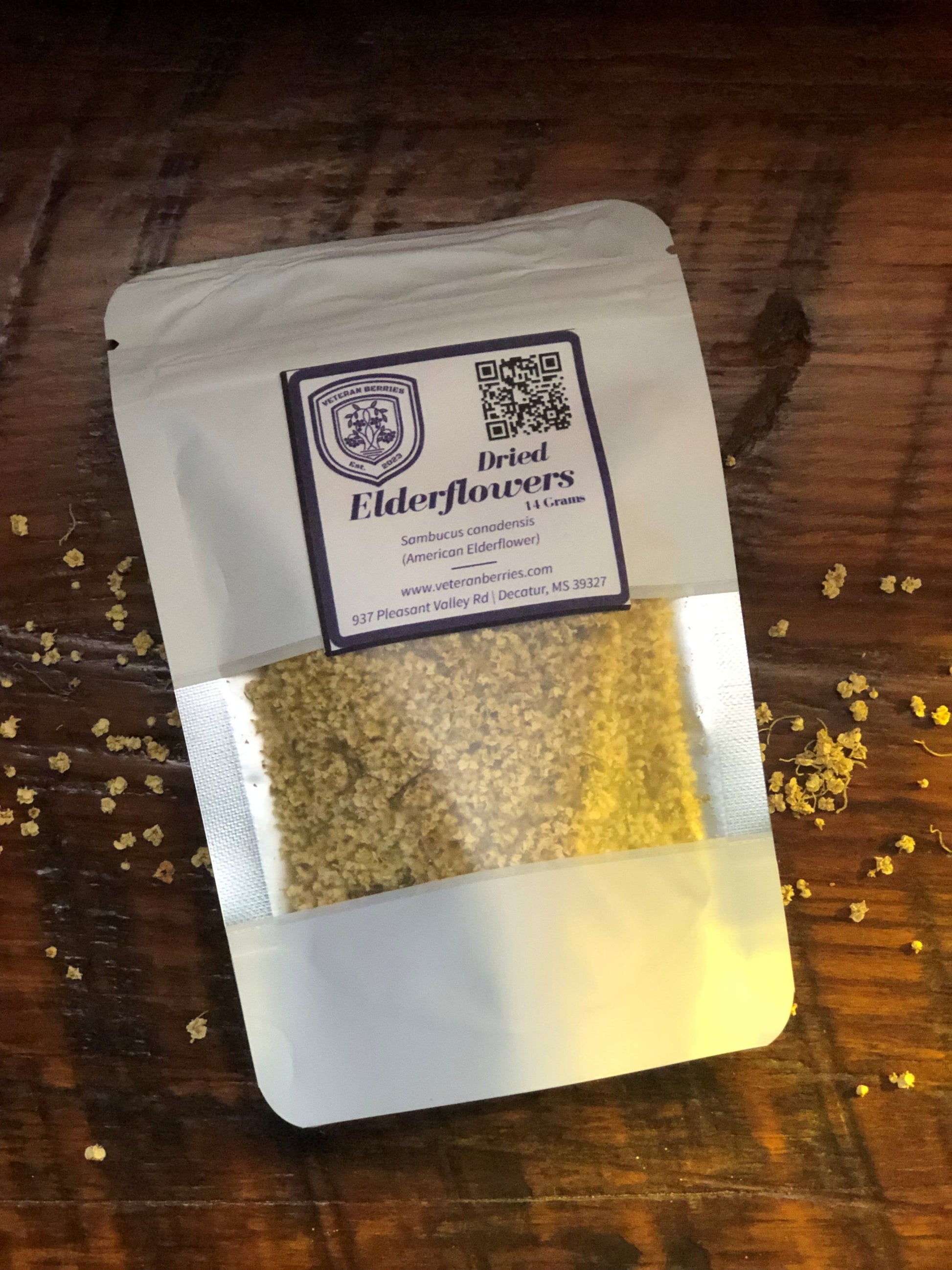 Package of dried elderflowers on a wooden surface