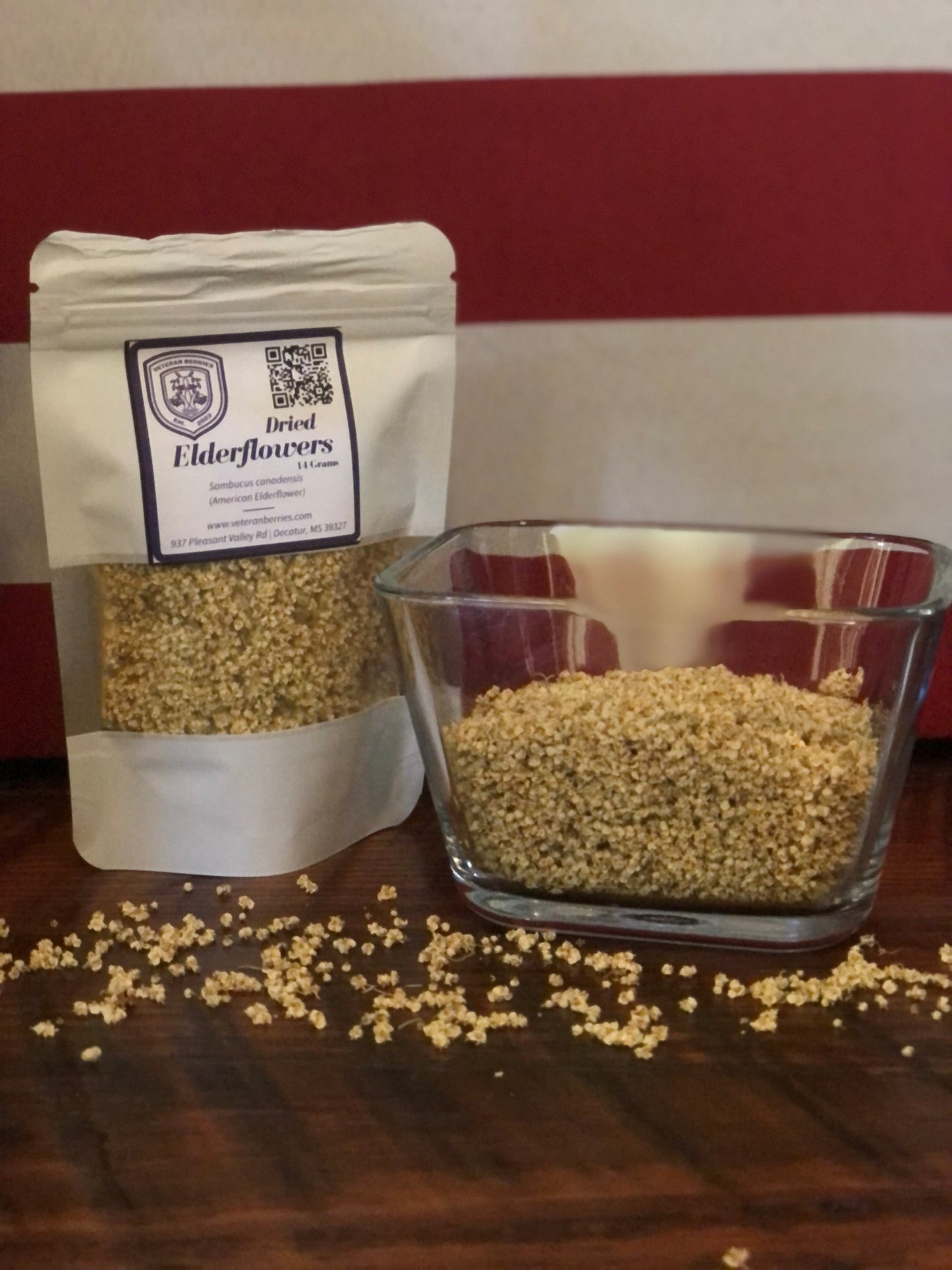 Clear glass container and white packaging with label on a wooden surface with US Flag as backdrop.